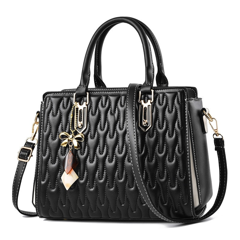 Klassisk lædertaske i sort vegansk PU-læder med præget overflade og sløjfevedhæng