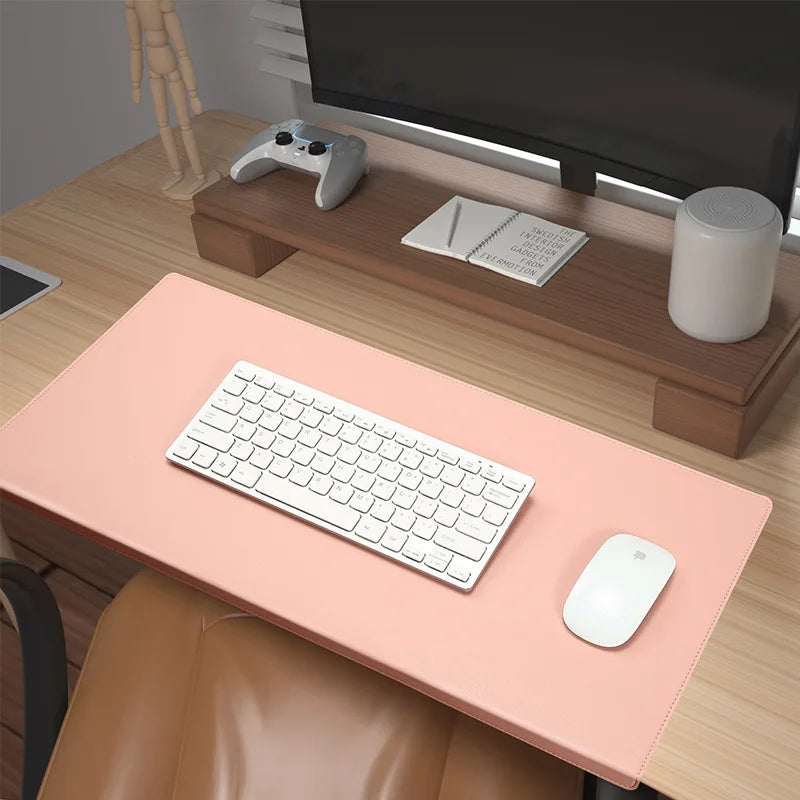 Deskpad i blå kunstlæder med gaming-setup og mus