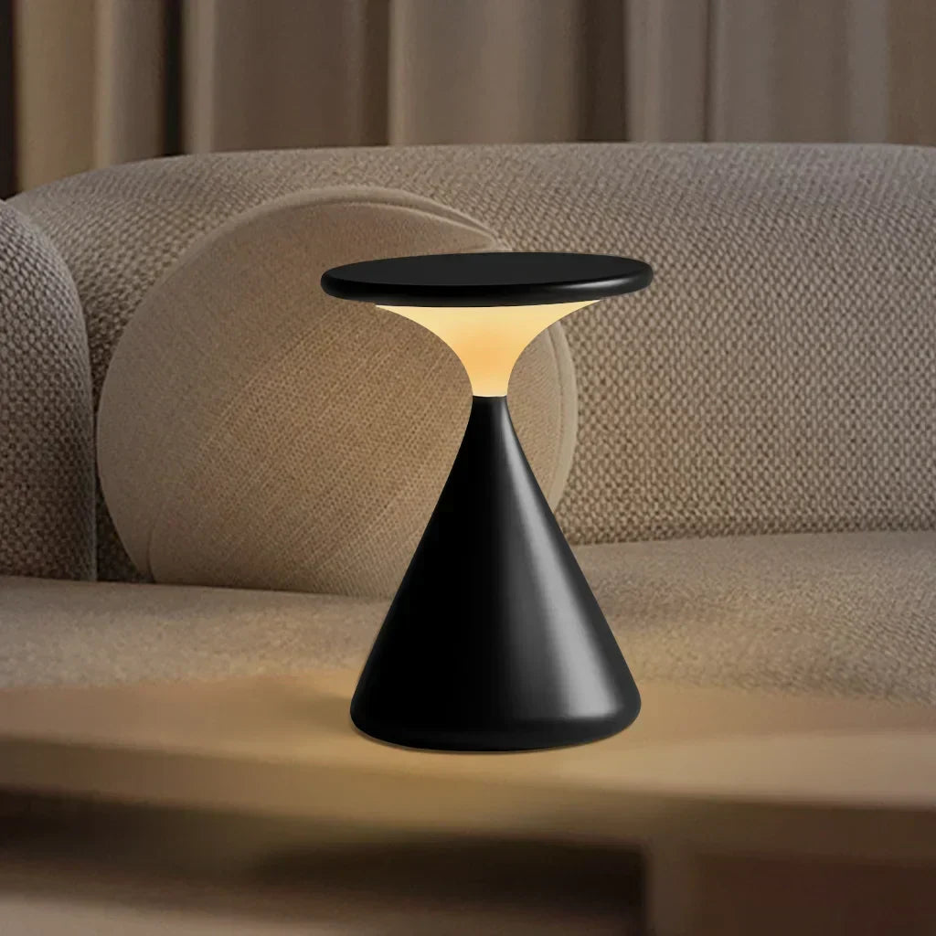 Bordlampe i beige med timeglasdesign på bord i stue