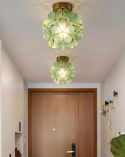 Detaljebillede af guldfarvet jernramme på blomsterloftlampe