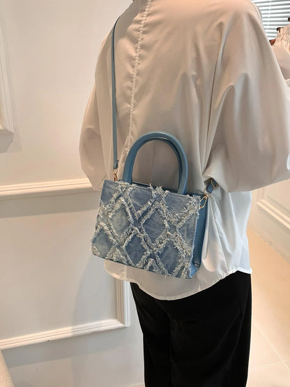 Blå denim crossbody taske båret over skulderen