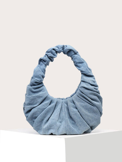 Foldbar skuldertaske i blå denim med cloud-inspireret form og vintage stil
