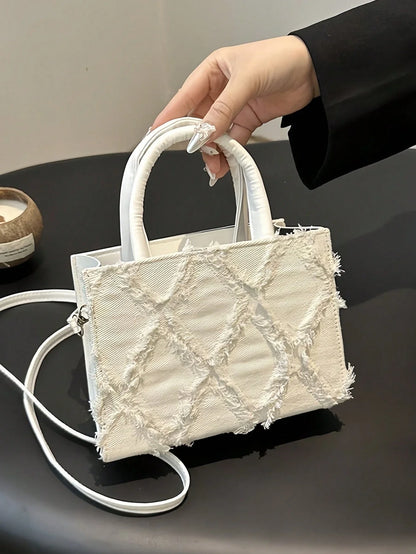 Sort lille håndtaske med diamantmønster set fra siden