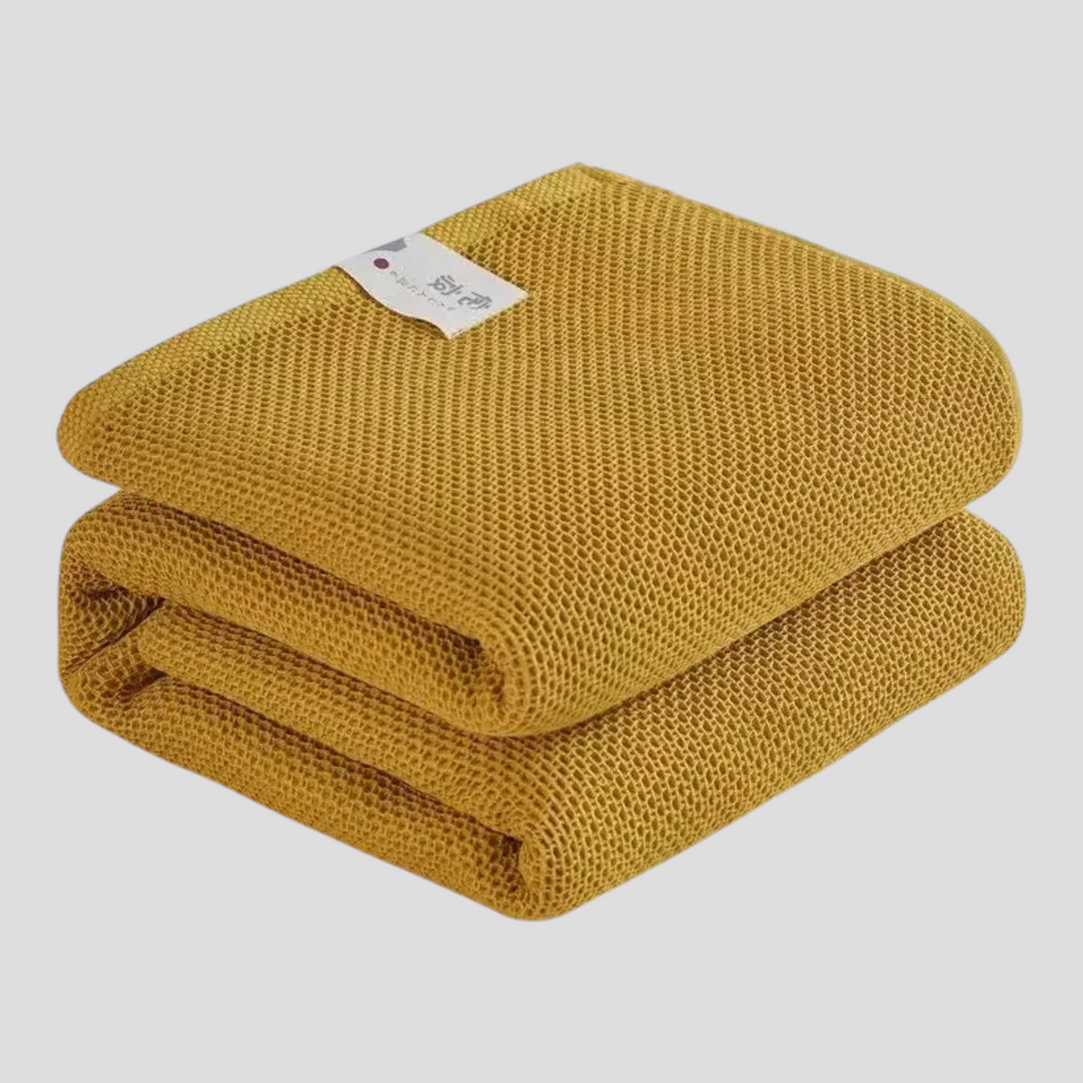 Sommerdyne foldet på seng – let og kompakt
