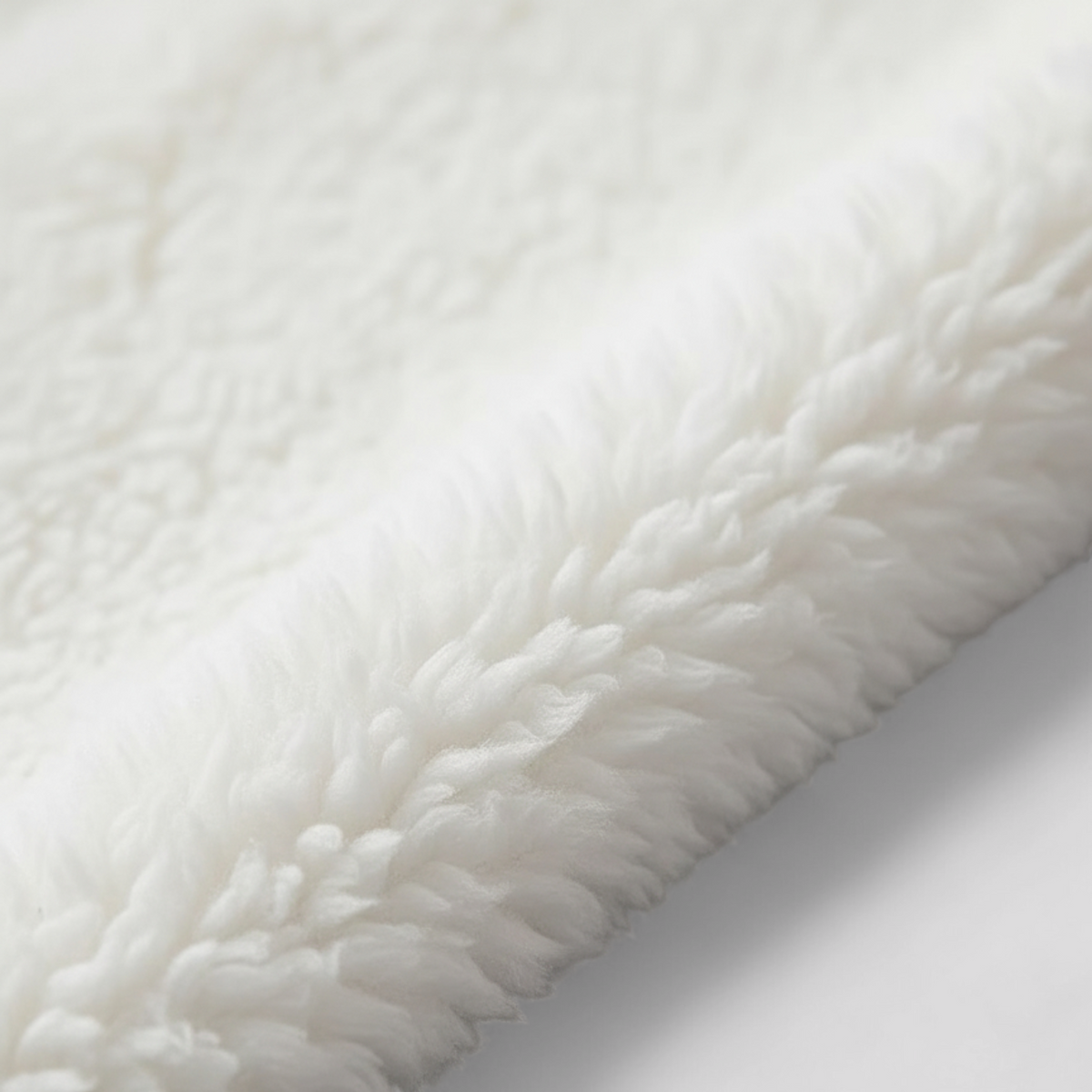 Blødt king size tæppe i fleece vist i brug på sofa