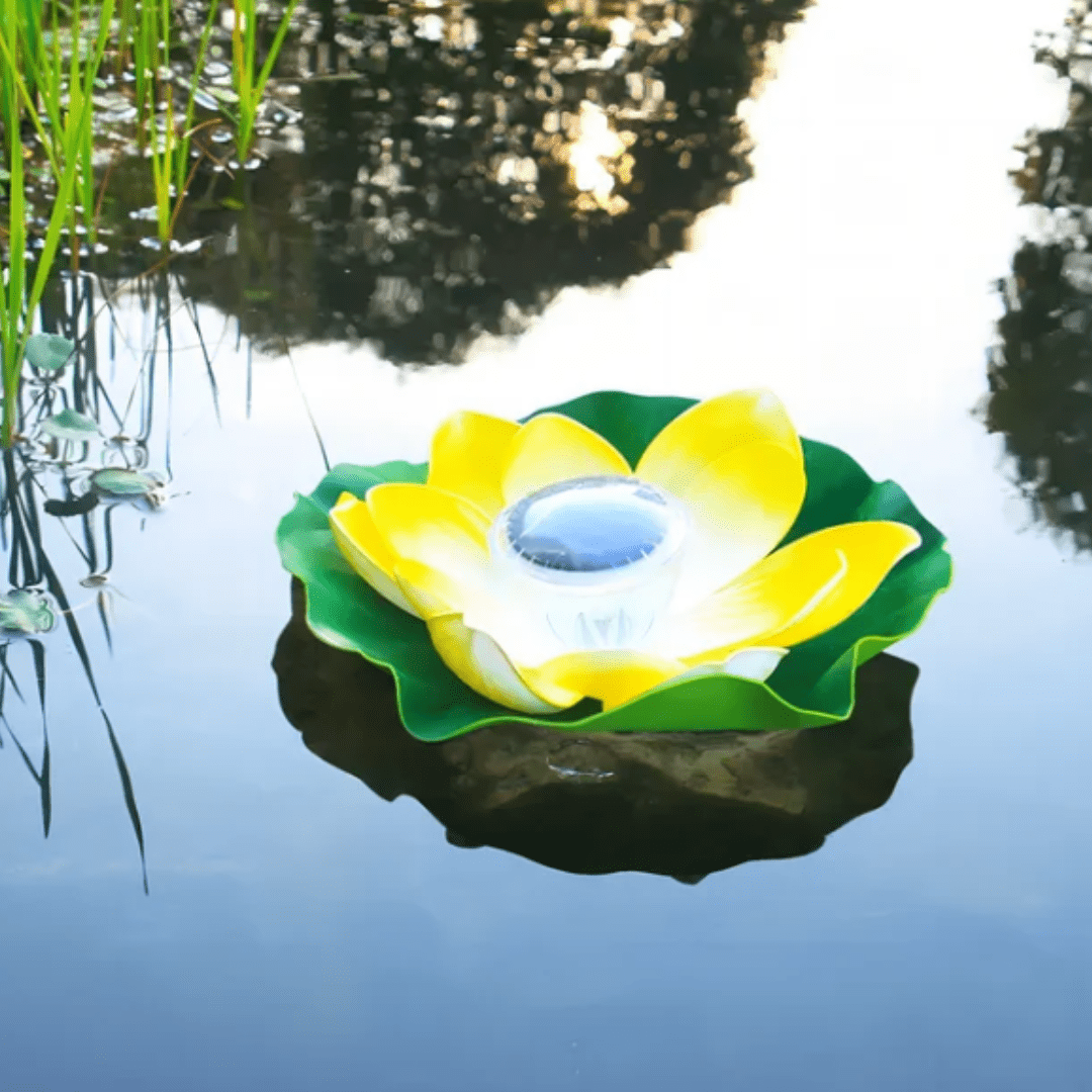 Solcellespring flydende på vand i have med farverige LED-refleksioner