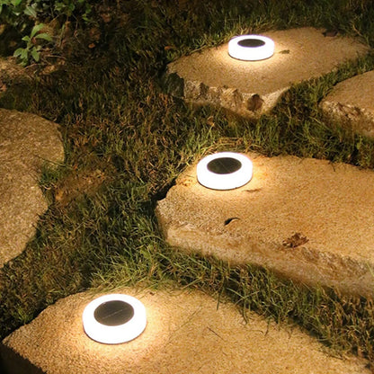 Beige solcellelamper til haven placeret på flad terrasseflade